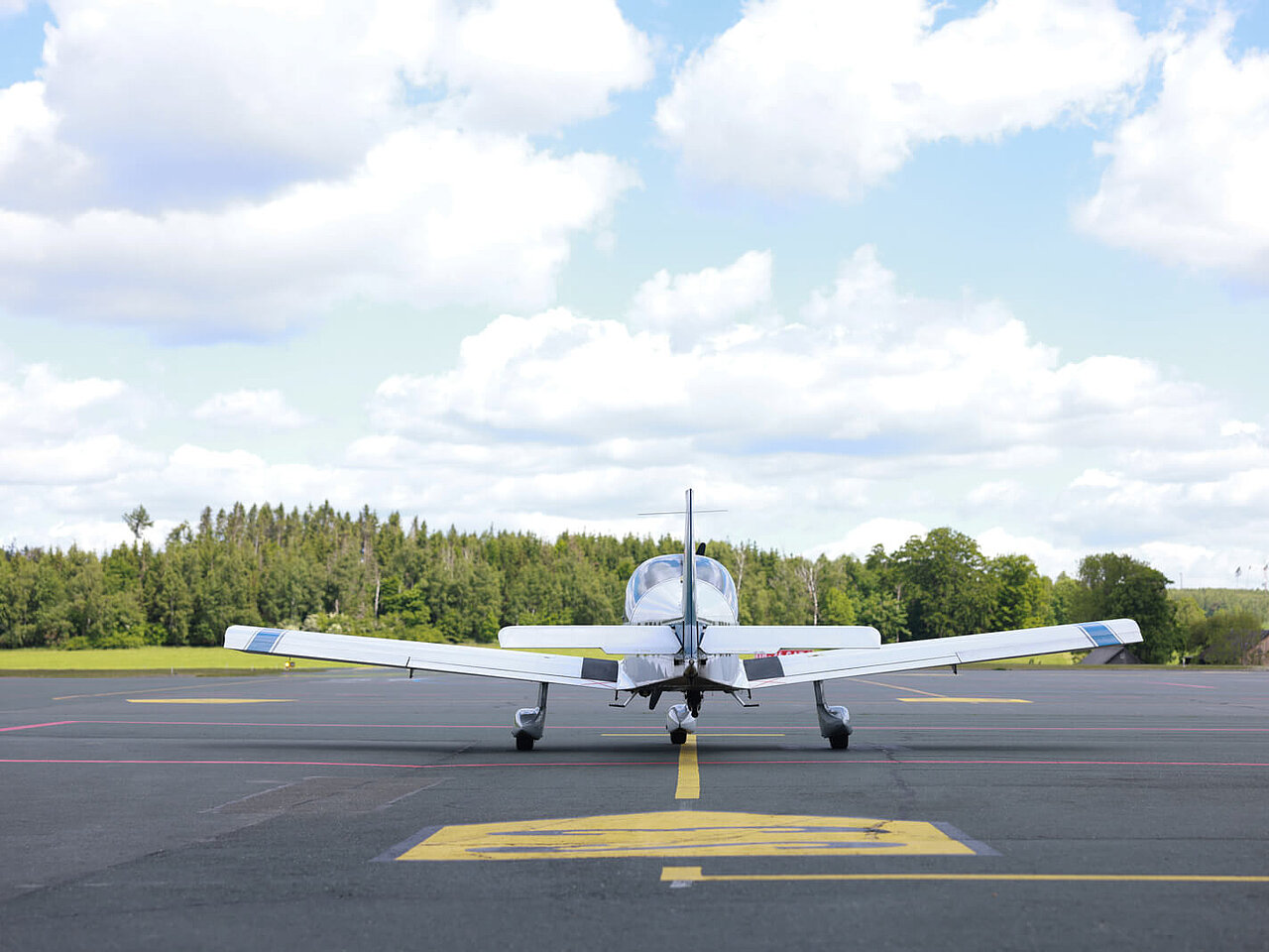 Das Bild zeigt ein Sportflugzeug zum Start bereit auf der Startbahn des Flughafen Hof-Plauen